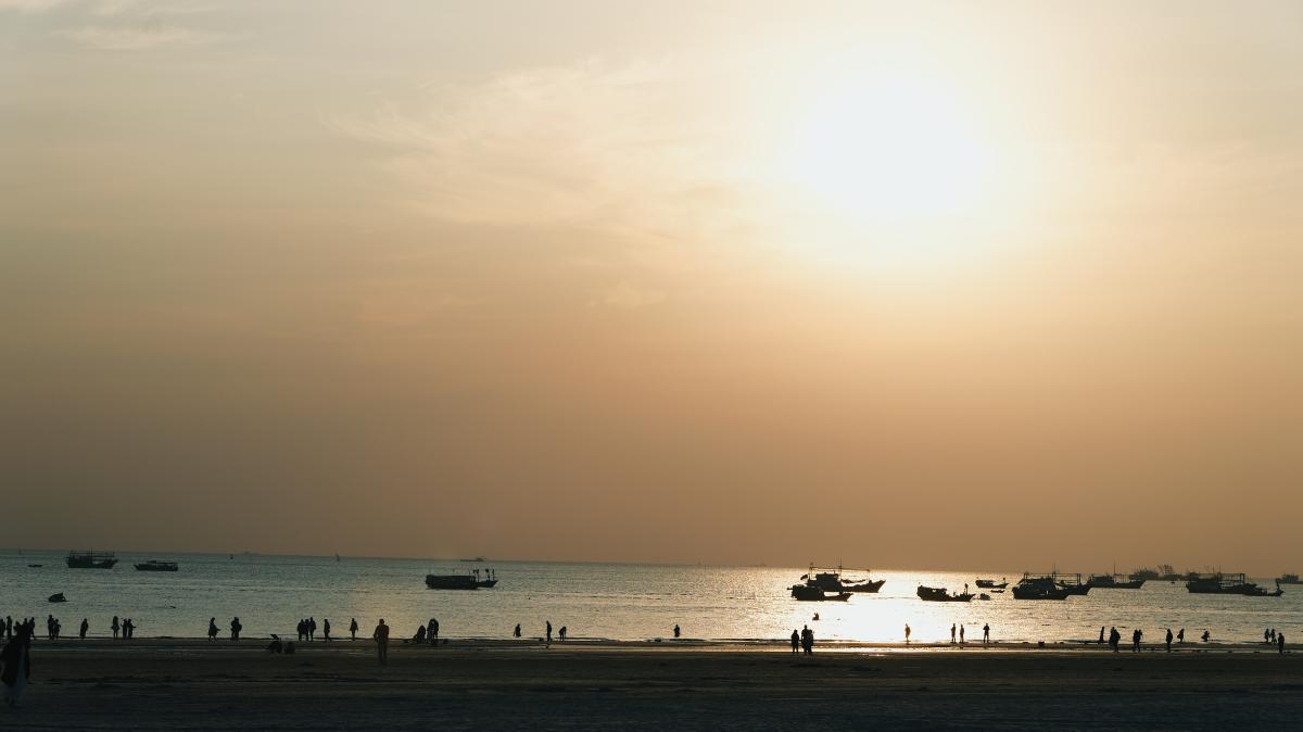 夕阳下海滩上的人群与渔船.JPG