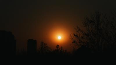 雾霾中城市建筑的日落剪影